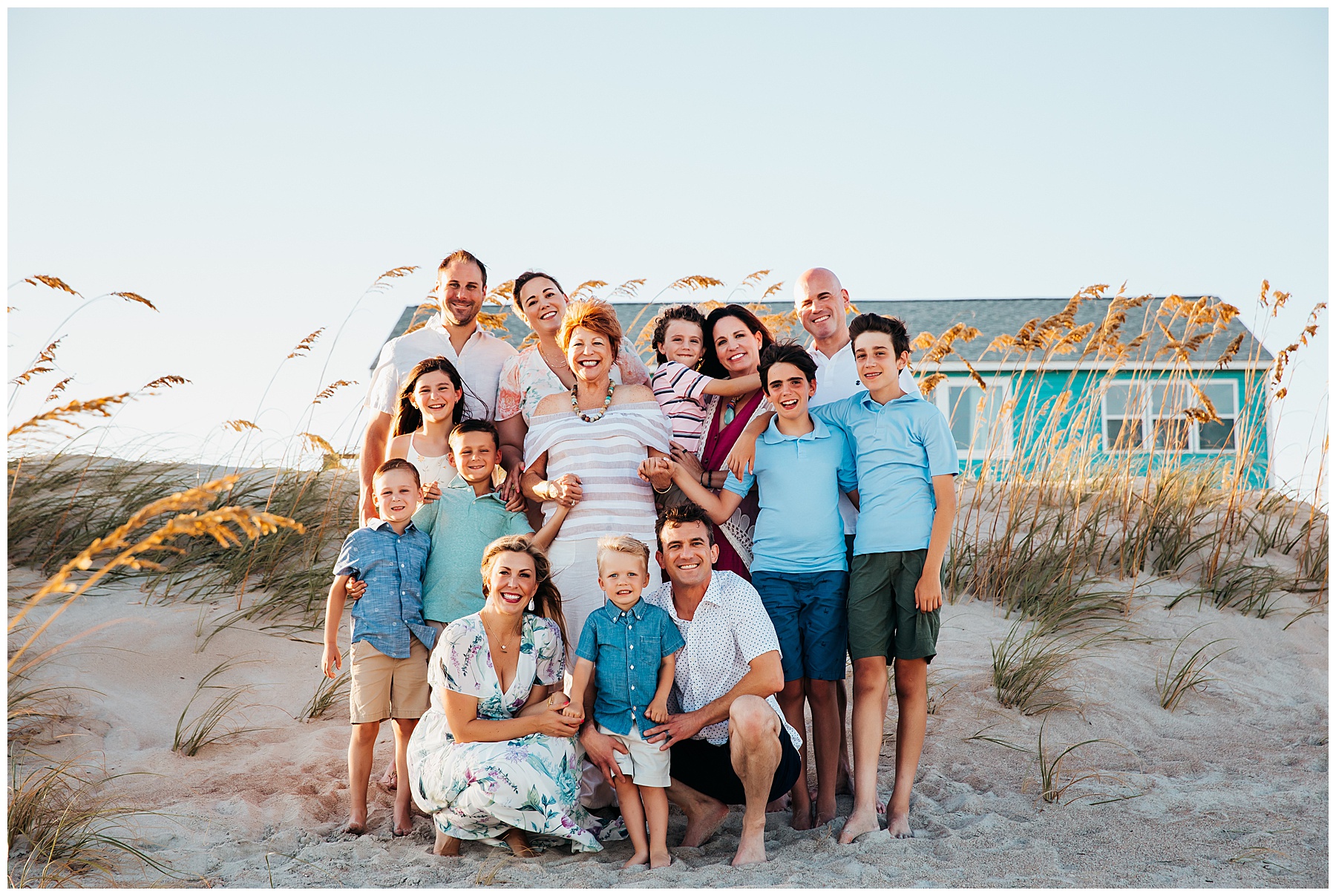 Extended family posing together on the beach.